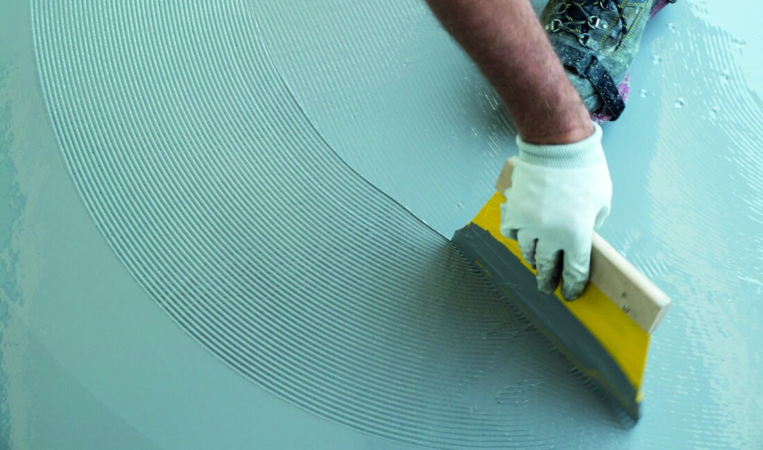 construction worker renovates balcony floor and spreads watertight resin and glue